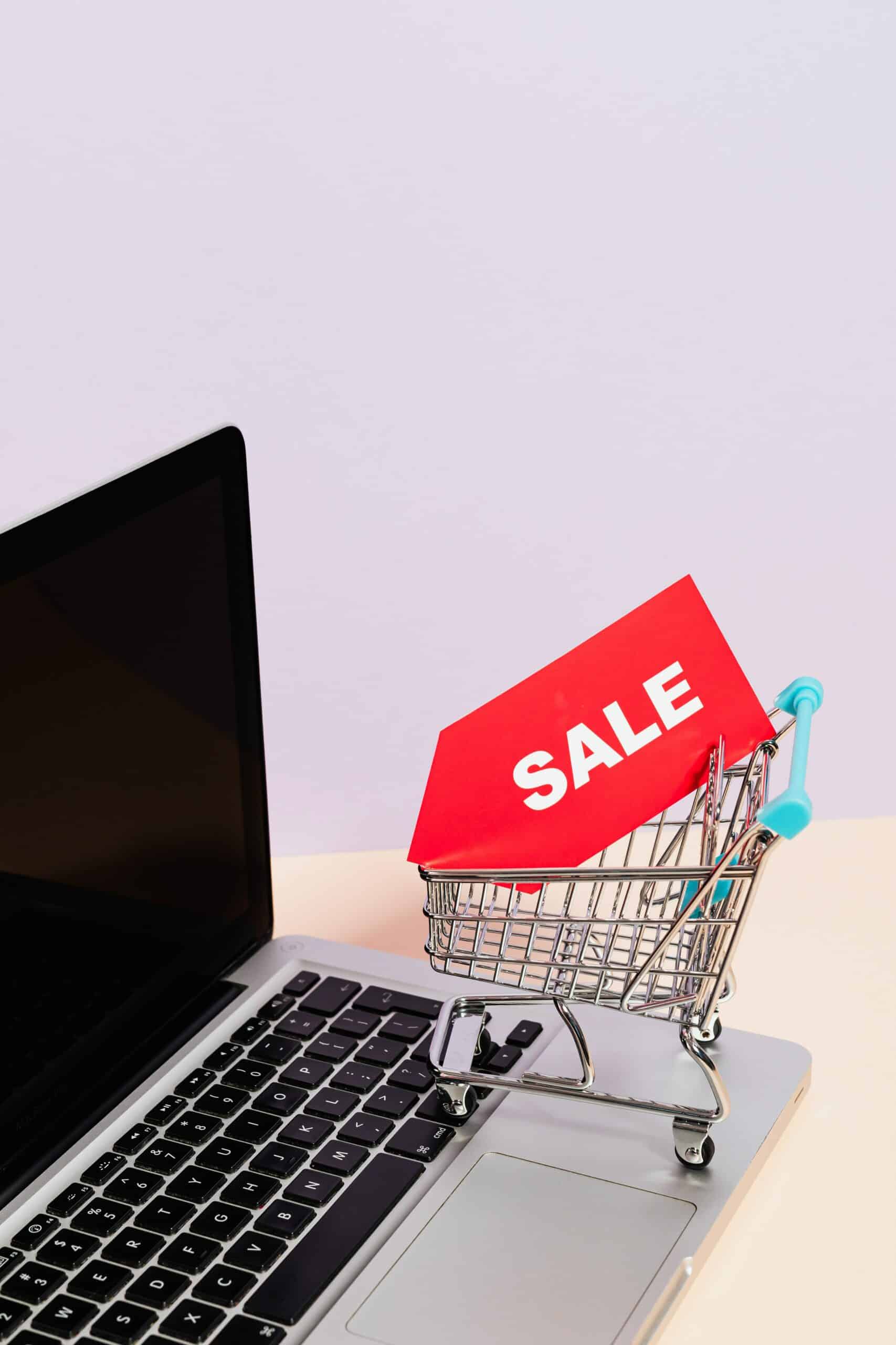 Laptop with shopping cart and sale sign